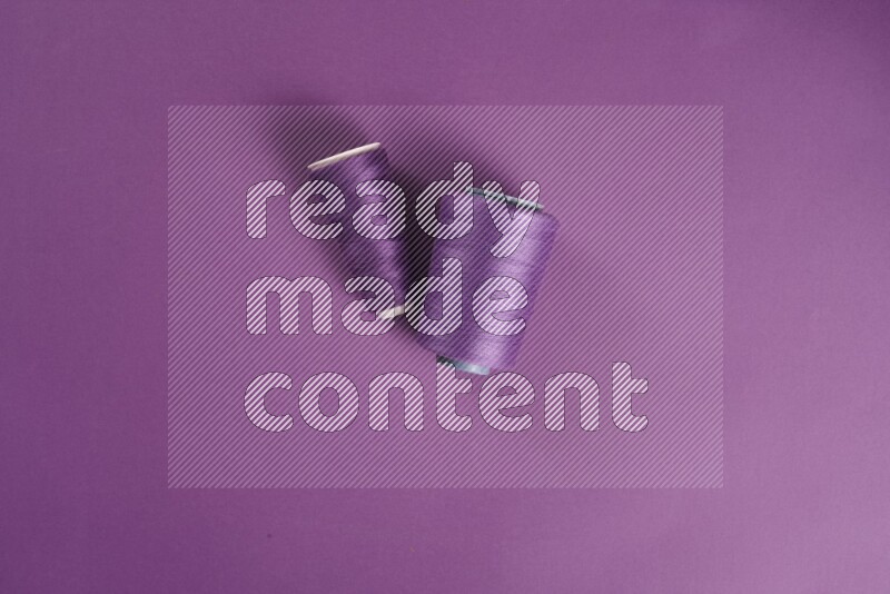A purple collection of sewing and tailoring tools arranged on a purple background