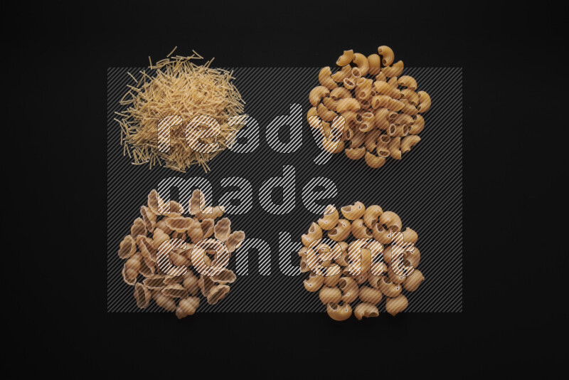 Different pasta types in bunches on black background