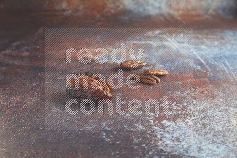 one pecan stuffed madjoul date on a rustic reddish background