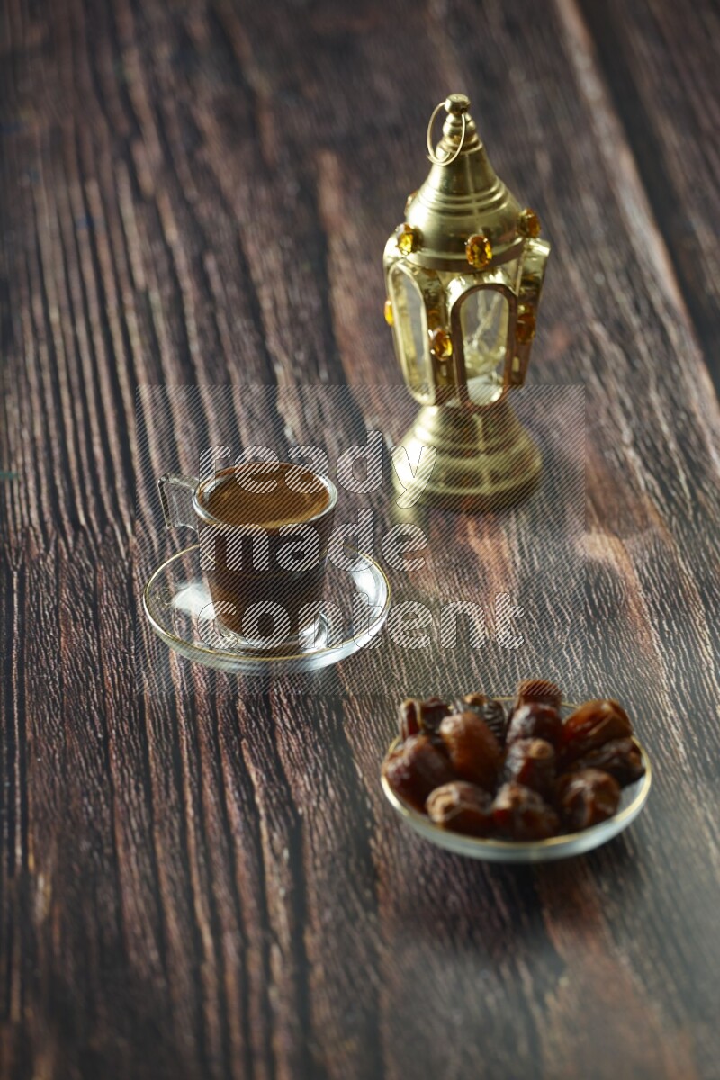 A golden lantern with different drinks, dates, nuts, prayer beads and quran on brown wooden background