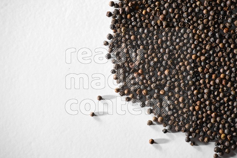 Black pepper on a white flooring