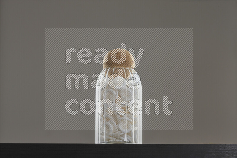 أزرار متنوعة في وعاء زجاجي علي خلفية سوداء