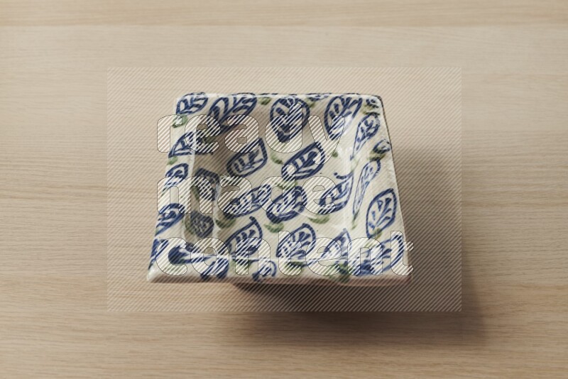 صحن فخاري مزخرف على خلفية خشبية فاتحة