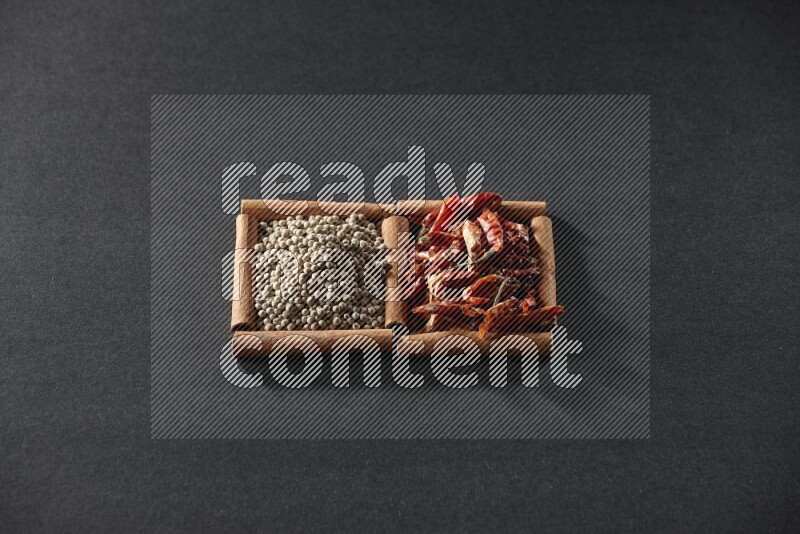 2 squares of cinnamon sticks full of chilis and white peppers on black flooring