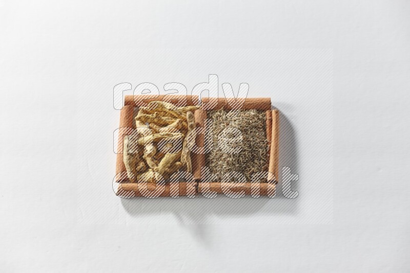 2 squares of cinnamon sticks full of cumin and turmeric fingers on white flooring