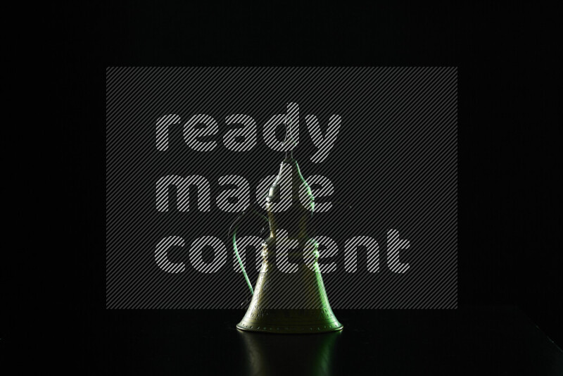 A turkish coffee pot with colored rim light against black background