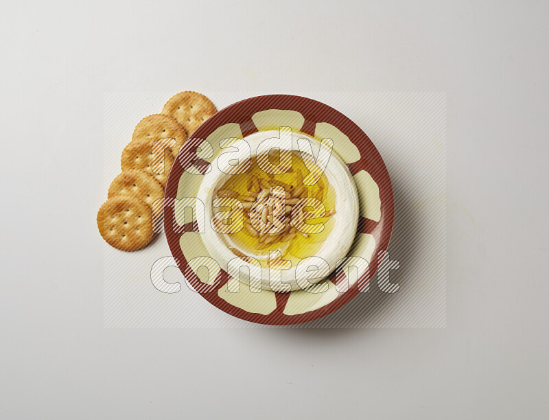 Lebnah garnished with pine nuts in a traditional plate on a white background