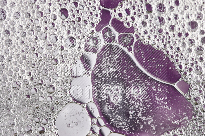 Close-ups of abstract soap bubbles and water droplets on purple background
