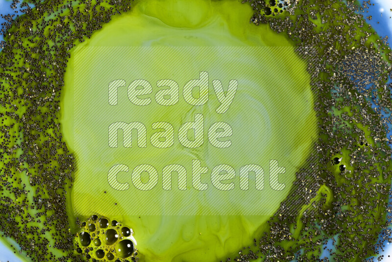 لقطة مقربة لبريق ذهبي متلألئ منتشر على خلفية من اللون الأزرق والأخضر في حركات دائرية