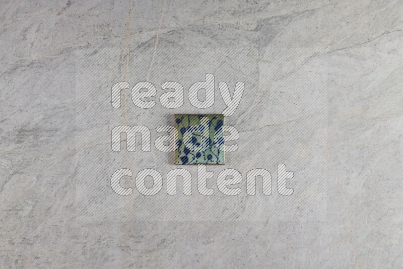 A decorative pottery coaster on grey marble background