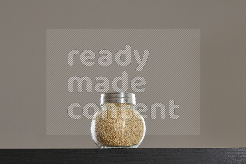 Sesame in a glass jar on black background