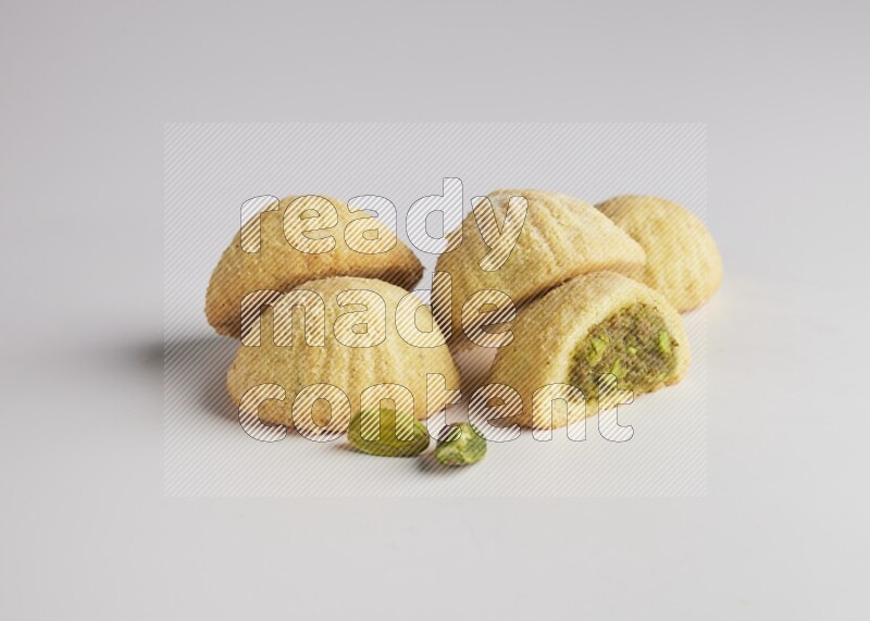 Five Pieces of Maamoul filled with pistachio  paste one of them is cut direct on white background