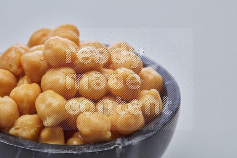 Close up shot of boiled chickpeas in a container on white background