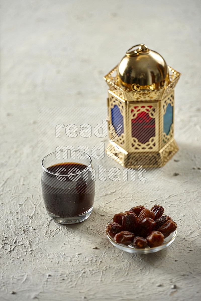 A golden lantern with drinks, dates, nuts, prayer beads and quran on textured white background