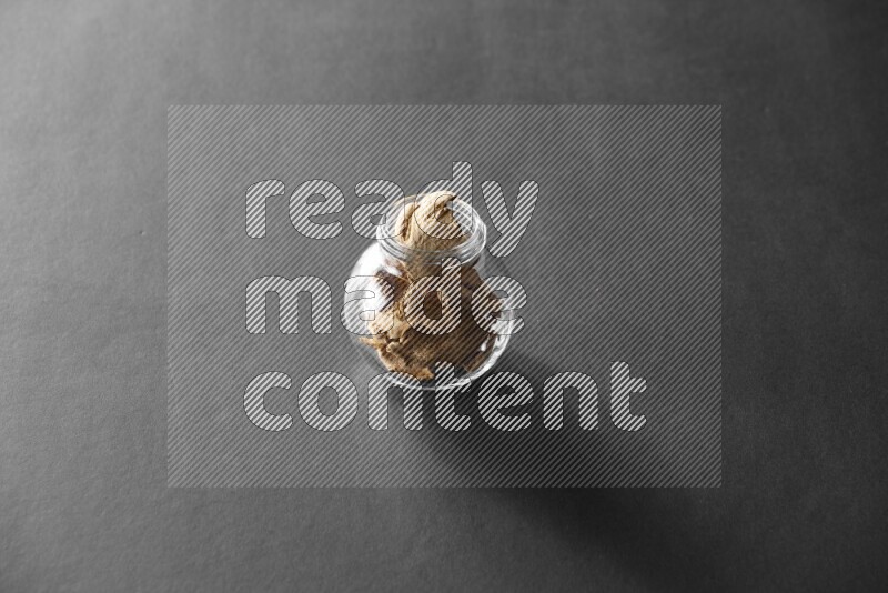 زنجبيل مجفف في وعاء زجاجي علي خلفية سوداء