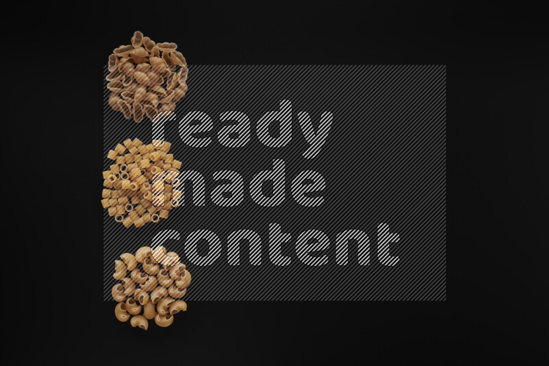 Different pasta types in 3 bunches on black background