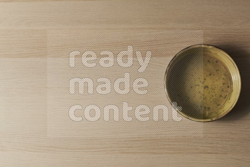 وعاء فرن فخاري متعدد الألوان علي خلفية خشبية فاتحة