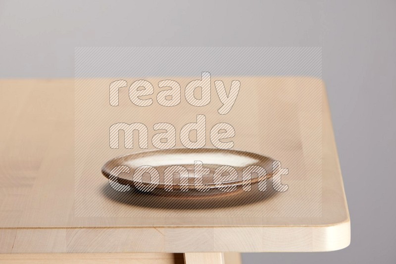 multi-colored pottery Plate on a wooden table edge