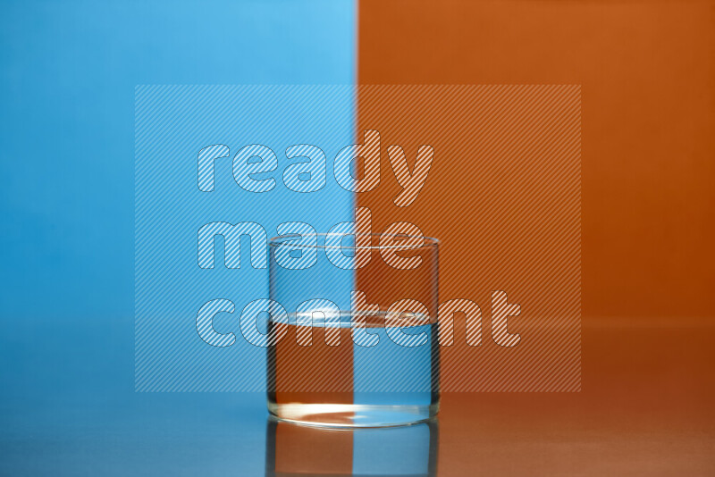 The image features a clear glassware filled with water, set against blue and dark orange background