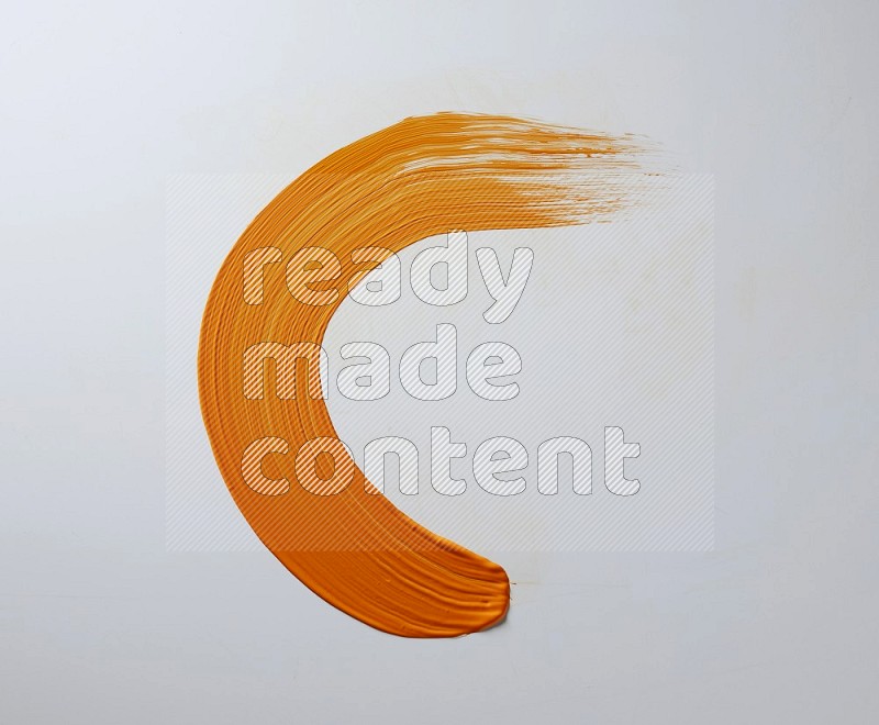 An orange half circular painting brush stroke on white background