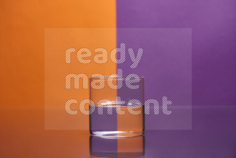 تظهر الصورة أواني زجاجية ممتلئة بالماء موضوعة على خلفية من اللونين البرتقالي والأرجواني
