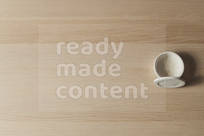 وعاء فخاري أبيض على خلفية خشبية فاتحة