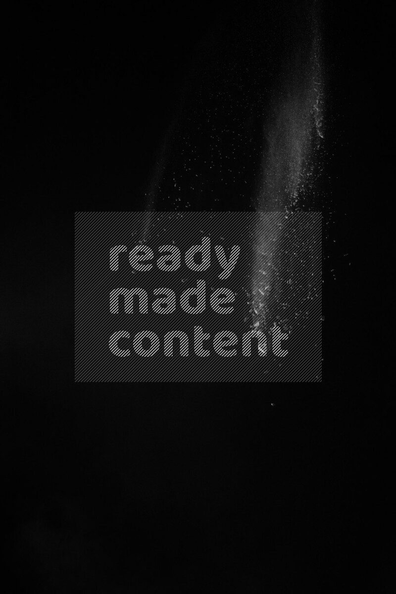 A side view of white powder explosion on black background