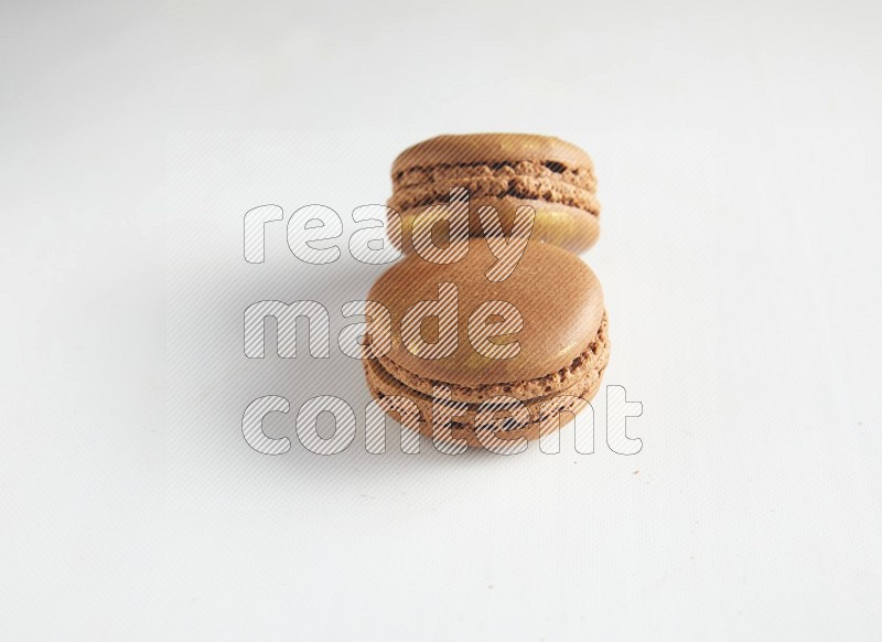 45º Shot of two Brown Coffee macarons on white background