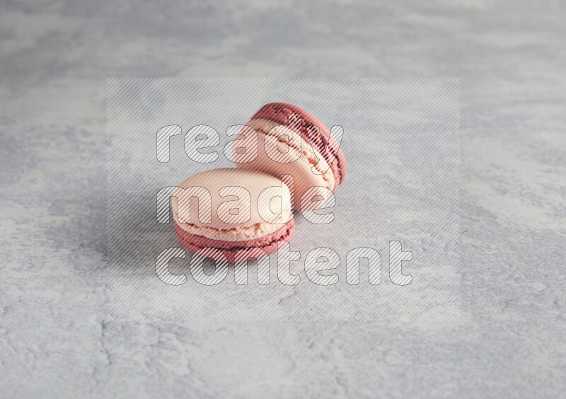45º Shot of two Pink Litchi Raspberry macarons  on white  marble background