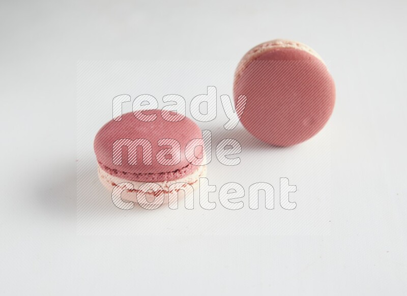 45º Shot of two Pink Litchi Raspberry macarons on white background
