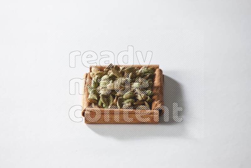 A single square of cinnamon sticks full of cardamom on white flooring