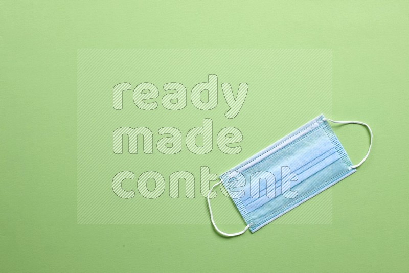 A face mask on green background (back to school)