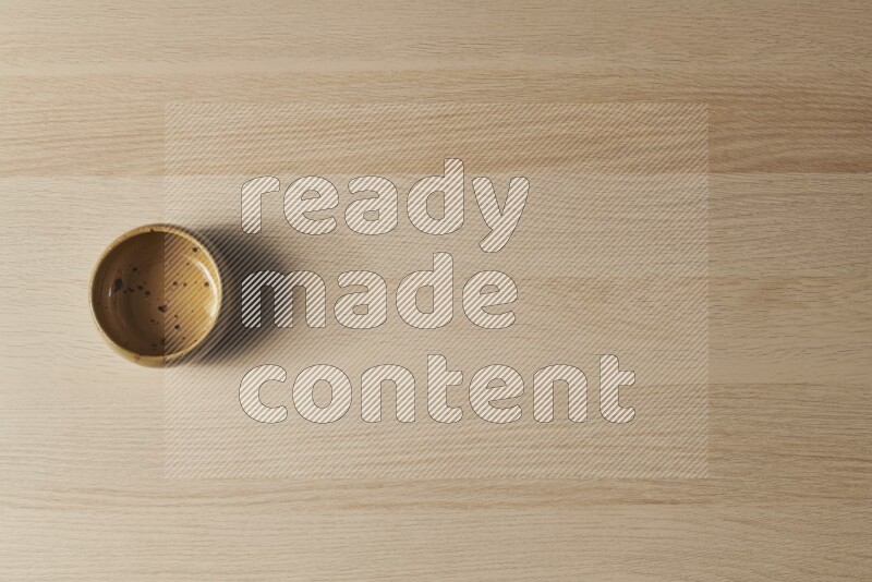 A multicolored pottery bowl on light wooden background