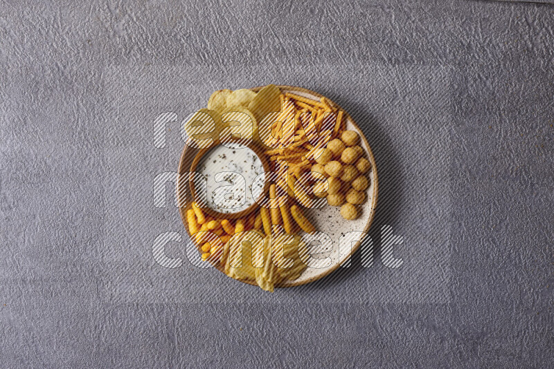 Assorted snacks in pottery bowls on grey background
