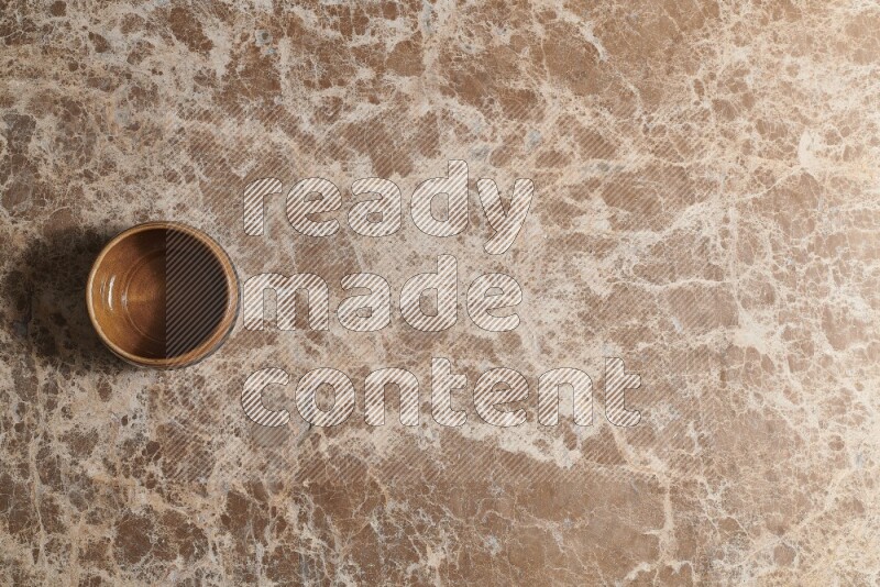 Top View Shot Of A Brown Pottery bowl On beige Marble Flooring