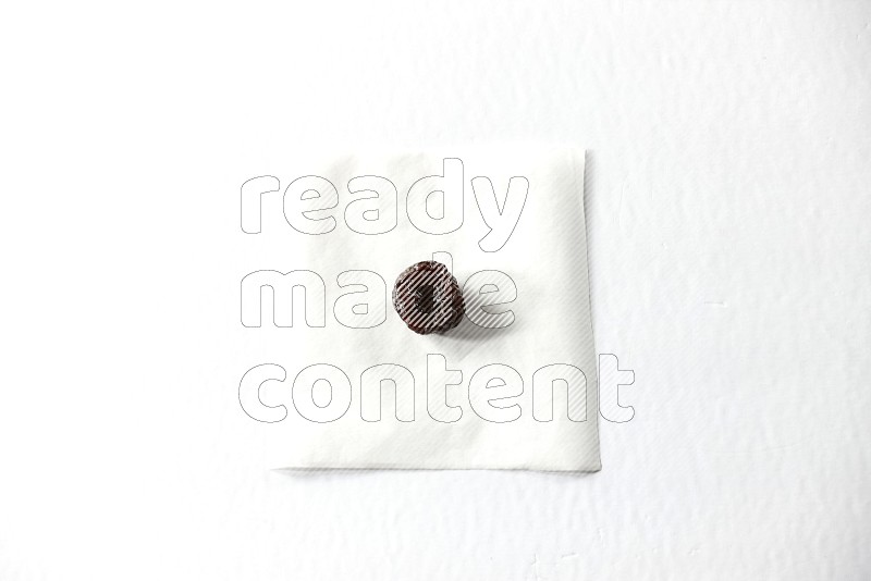 A dried plum on a piece of paper on a white background in different angles