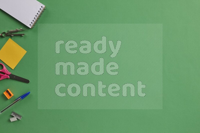 مستلزمات مدرسية مختلفة على خلفية خضراء