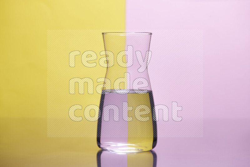 The image features a clear glassware filled with water, set against yellow and rose background