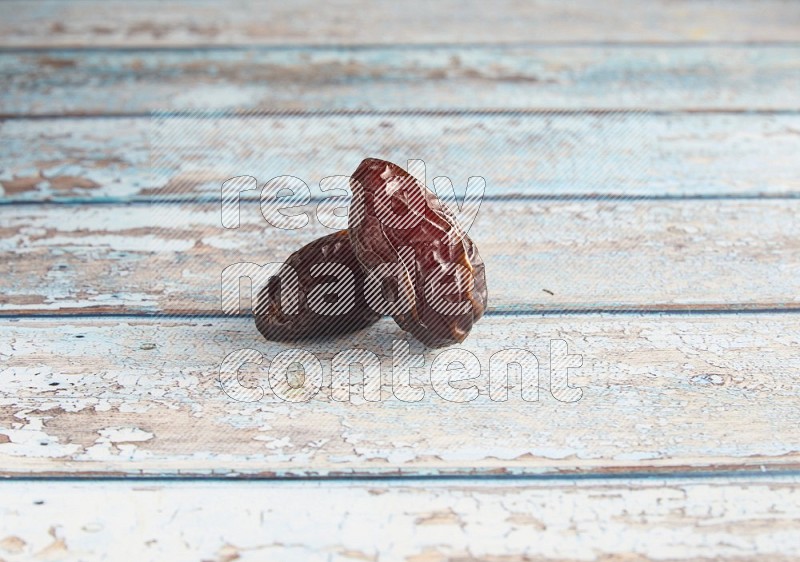 two madjoul dates on a light blue wooden background