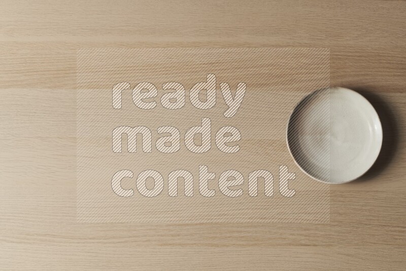 طبق من الفخار باللون البيج على خلفية خشبية فاتحة