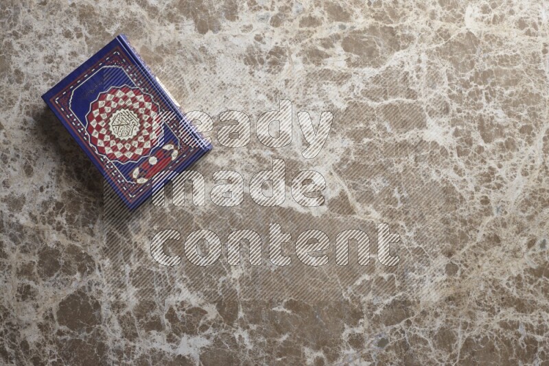 The holy Quran on beige marble background