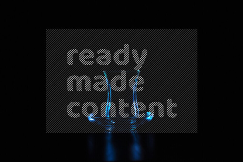 Glassware with rim light in blue against black background