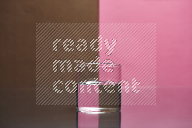 The image features a clear glassware filled with water, set against brown and pink background