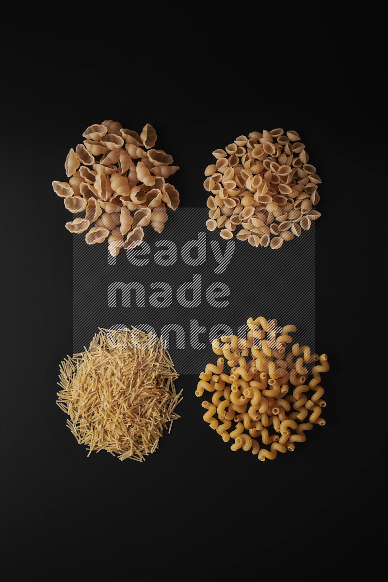 Different pasta types in bunches on black background