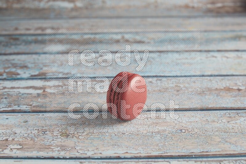 45º Shot of Red Velvet macaron on light blue wooden background