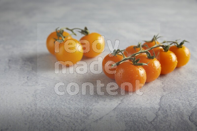 Mixed cherry tomato veins on a textured light grey background 45 degree