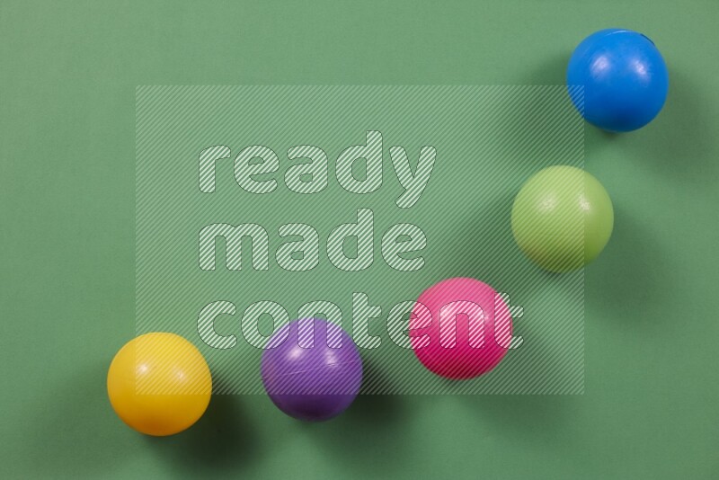 كرات بلاستيكية متعددة الألوان علي خلفيات ملونة مختلفة (ألعاب أطفال)