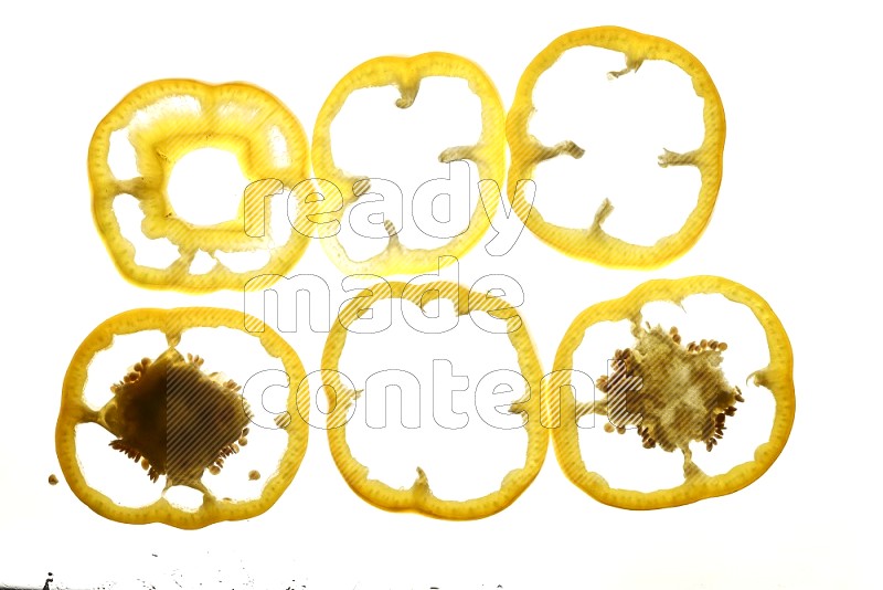 Yellow bell pepper slices on illuminated white background