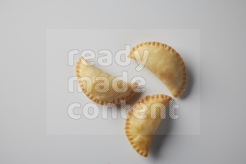 Three fried sambosa from a top angle on a white background