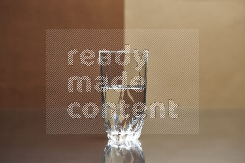 The image features a clear glassware filled with water, set against brown and beige background